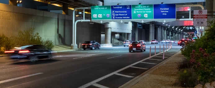 Roadway with airport signs above for terminal directions.