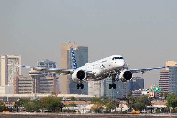 A Porter Airline plane coming in for a landing at Phoenix Sky Harbor with the downtown Phoenix skyline in the distance