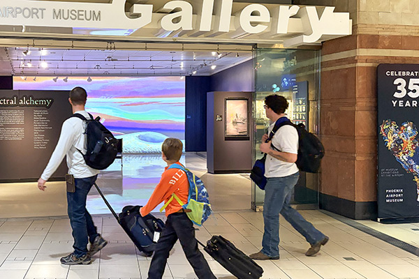 Travelers walking past the entrance to the Airport Museum Gallery in Terminal 4