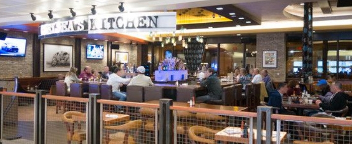 People sitting a bar counter eating.