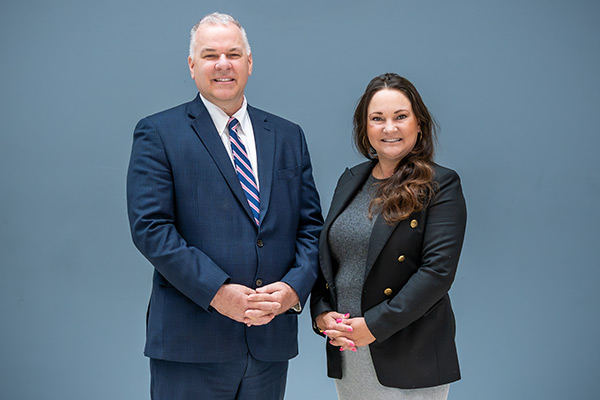 City of Phoenix Aviation Department Air Service Development and Marketing Administrator Lexie Van Haren posing with City Manager Ed Zuercher in front of a blue background