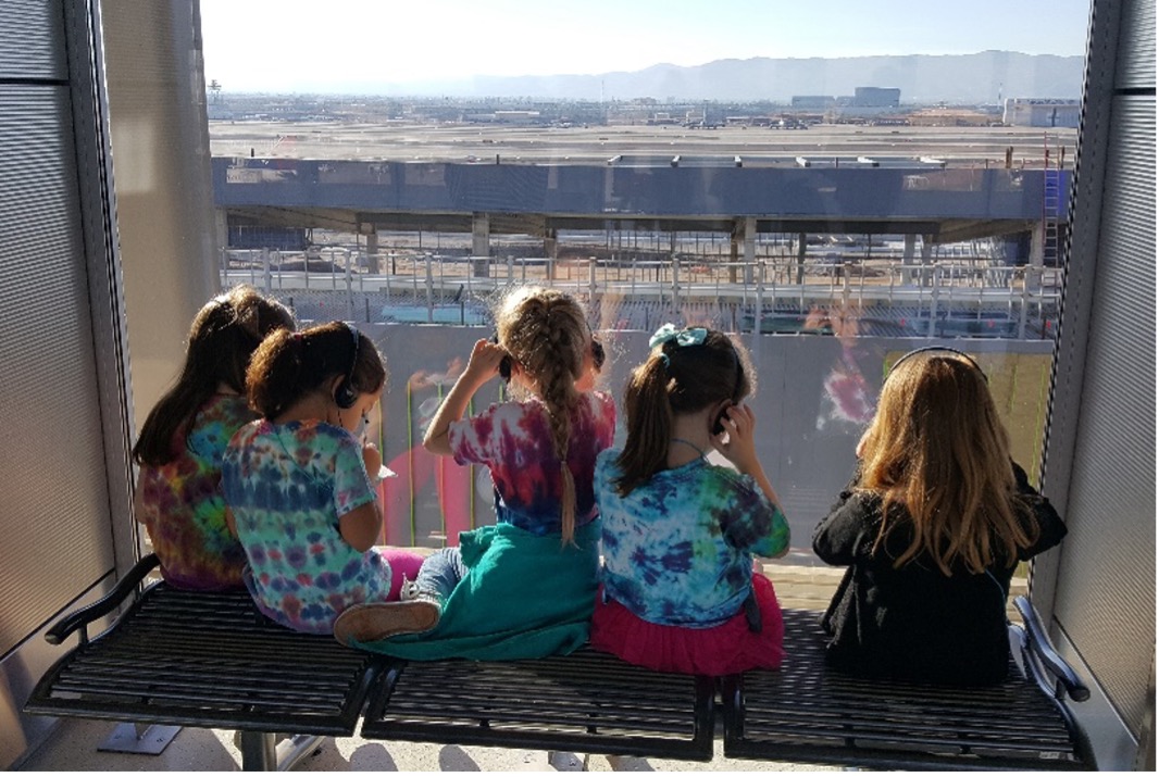 Children looking out of a terminal window at PHX Sky Harbor Airport