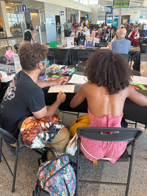 A couple sitting at a table working on wrrting poetry